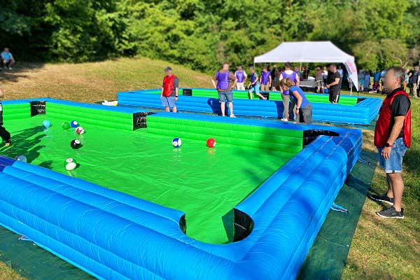 Team spielt Fußball-Billard auf aufblasbarem Spielfeld bei einem Outdoor-Firmenevent
